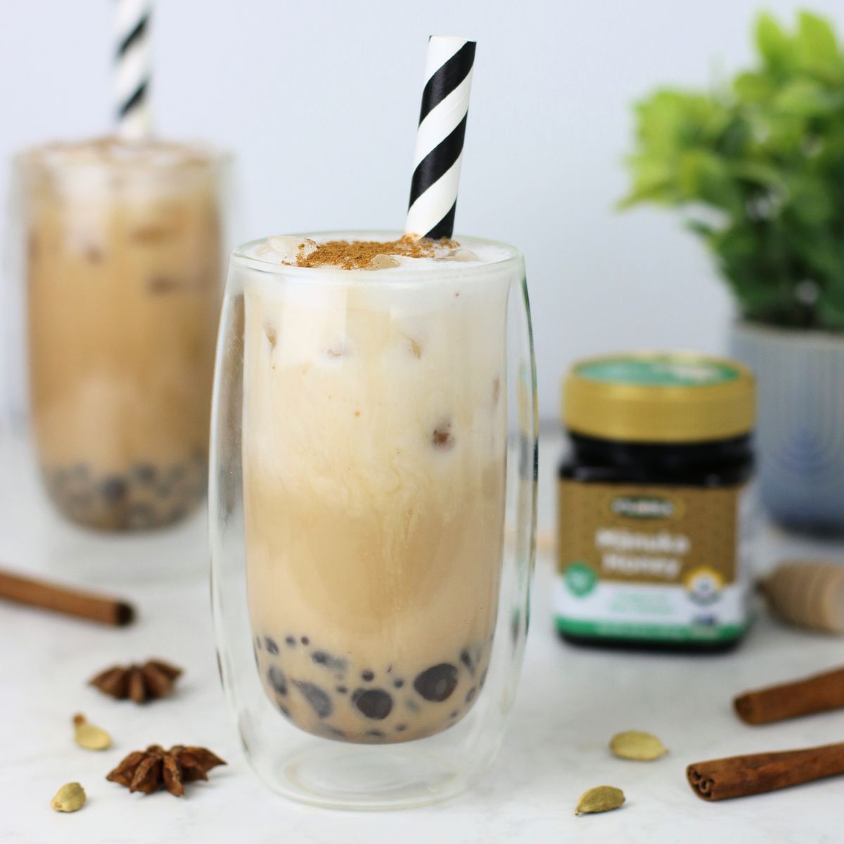 Two services of healthy chai bubble tea surrounded by ingredients