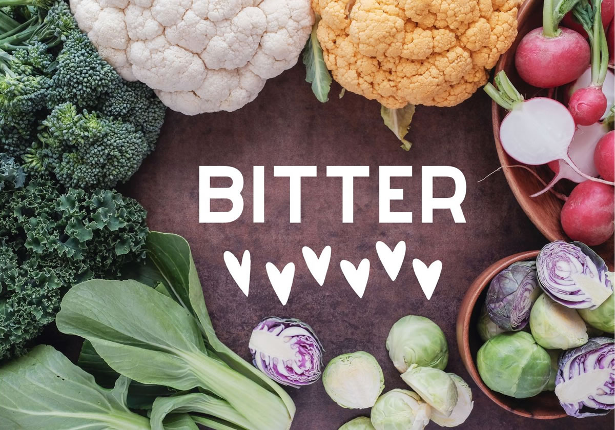 Kale, broccoli, brussels spouts, radish, and cabbage on a chopping block around the word bitter with hearts. 