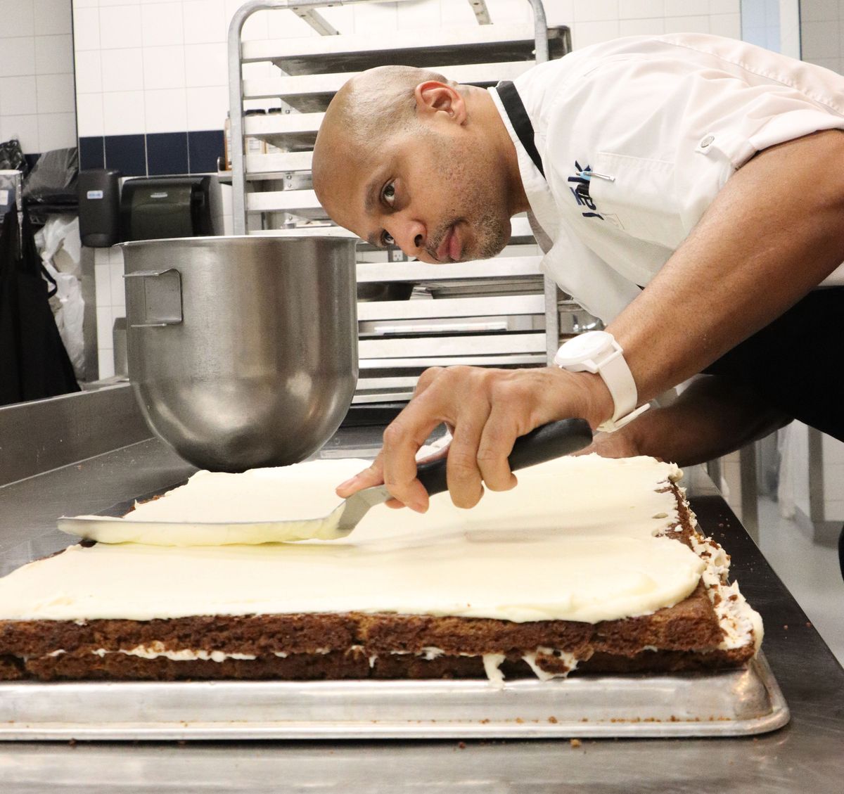 Pastry Chef Brian Holland icing a carrot cake
