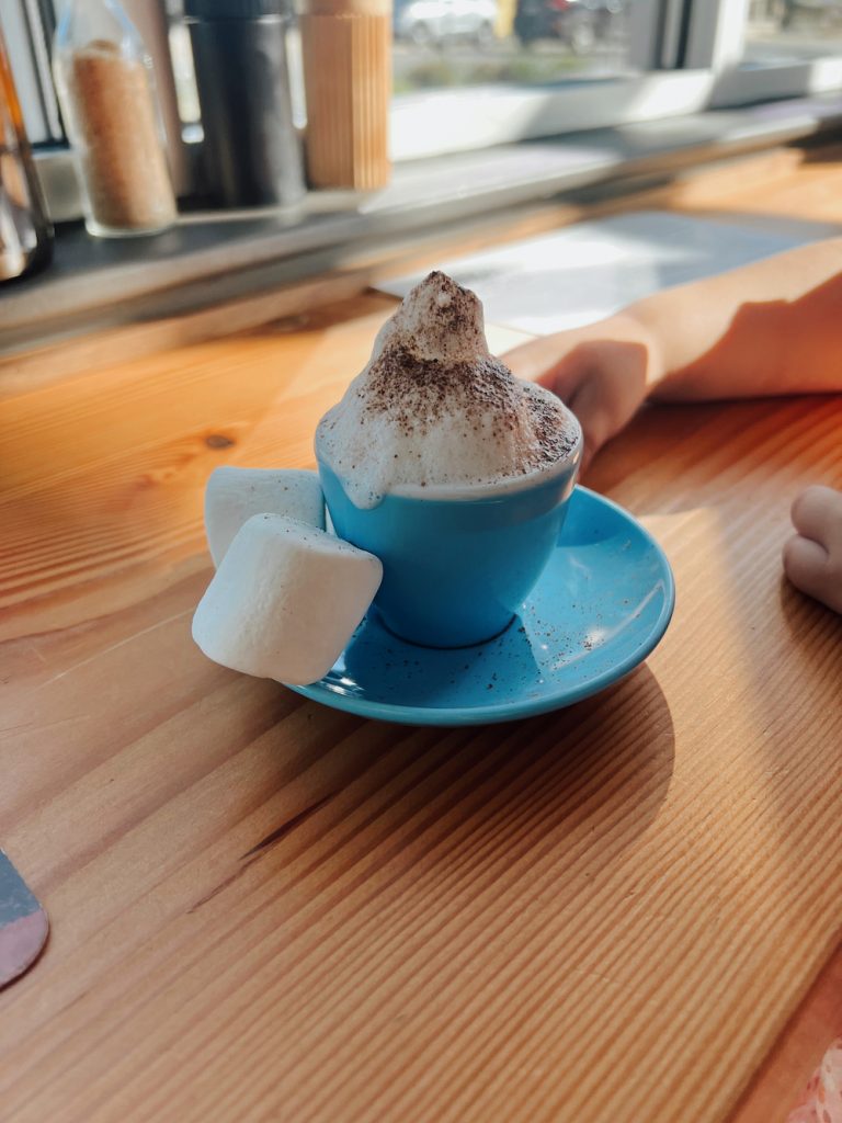 Babyccino mit Marshmallows in blauer Tasse und Untertasse bei Proud Mary in Austin.